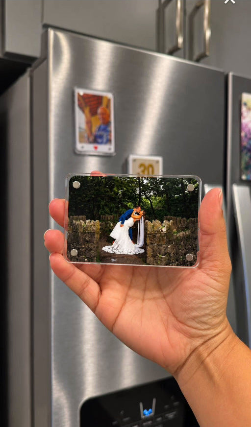 Full-photo acrylic wedding magnet held in front of refrigerator